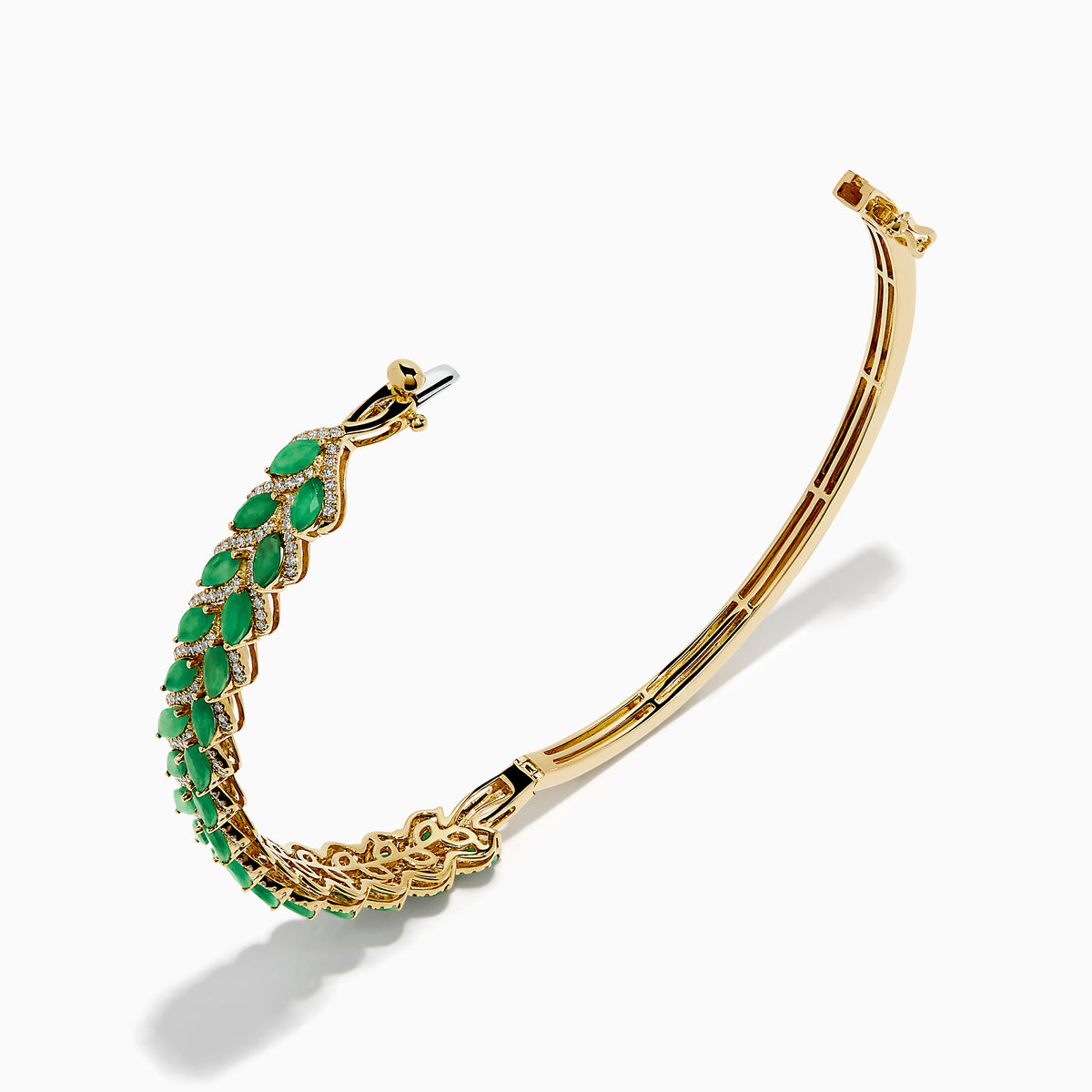 The 14K Yellow Gold Emerald and Diamond Marquise Leaf Bangle showcases an intricate leaf design with alternating emeralds and diamonds set along the band.