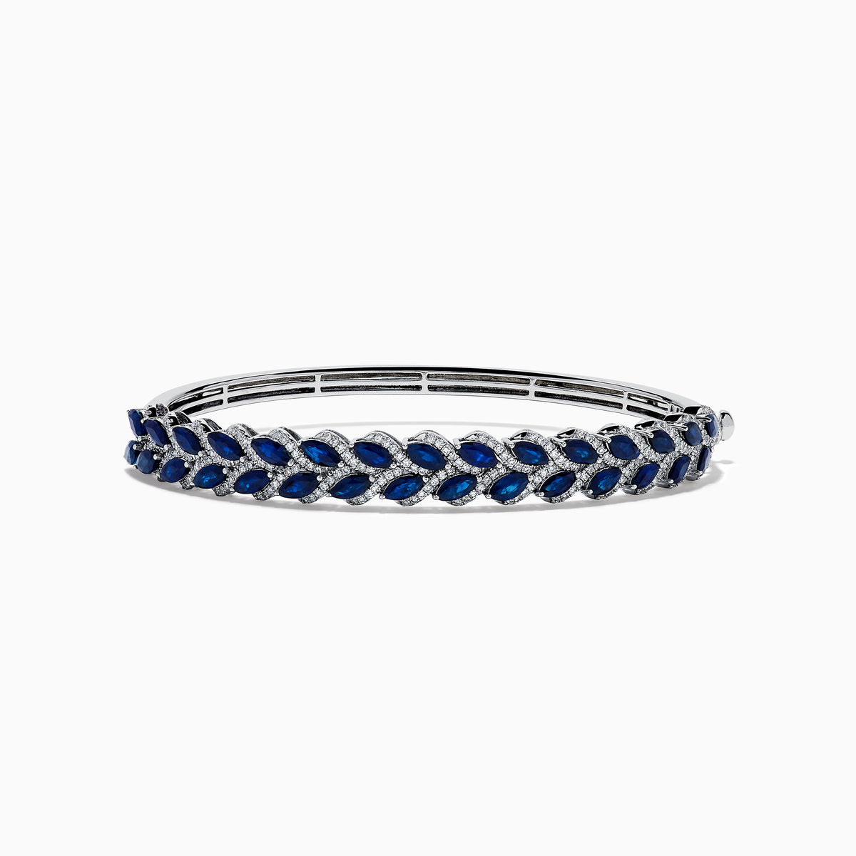 The 14K White Gold Sapphire and Diamond Leaf Motif Bangle features an elegant repeating leaf design with alternating blue sapphires and clear diamonds.