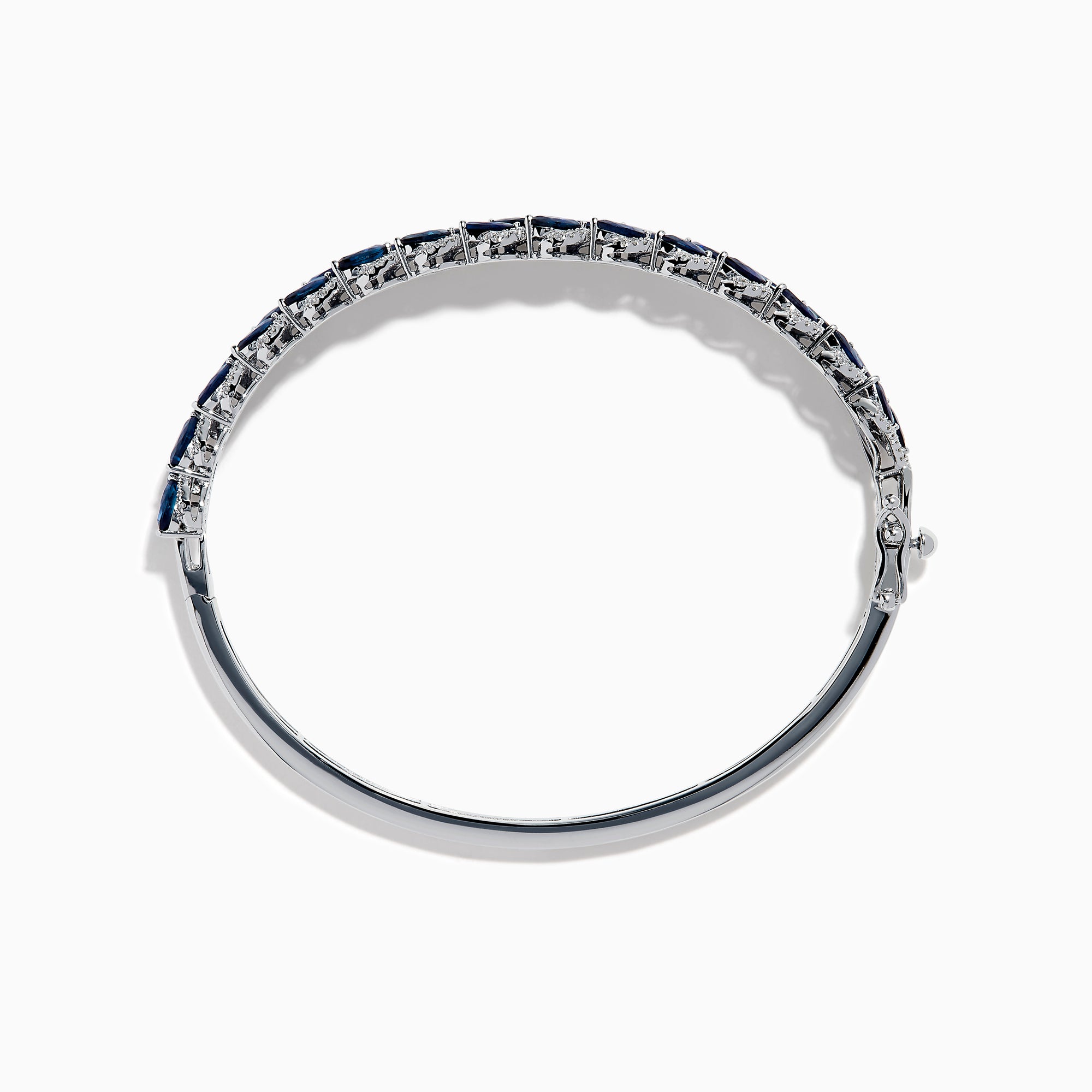 The 14K White Gold Sapphire and Diamond Leaf Motif Bangle features an elegant repeating leaf design with alternating blue sapphires and clear diamonds.