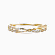 The 14K Yellow Gold Diamond Crossover Ribbon Bangle features overlapping bands in a crossover ribbon style, with some bands encrusted with sparkling diamonds for an elegant, layered look.