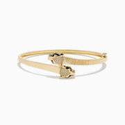 The Signature 14K YGold Diamond and Emerald Panther Bypass Bangle features twin panther heads with emerald eyes, diamond accents, and a textured ribbed band for a distinct, elegant look.