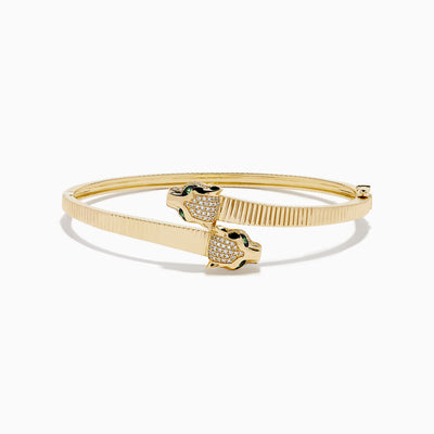 The Signature 14K YGold Diamond and Emerald Panther Bypass Bangle features twin panther heads with emerald eyes, diamond accents, and a textured ribbed band for a distinct, elegant look.