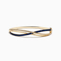 The Royal Bleu 14K Yellow Gold Blue Sapphire and Diamond Bangle showcases two intertwined bands—one set with diamonds, the other with vivid blue sapphires—in a graceful crisscross design.