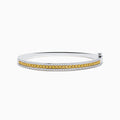 The Canare` 14K Two Tone Yellow and White Diamond Bangle features a central row of yellow diamonds bordered by sparkling white diamonds, all set in a stylish silver bracelet against a clean white background.