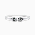 The Signature 14K White Gold Diamond and Tsavorite Bangle showcases two intricate panther heads facing each other, adorned with sparkling diamonds and vibrant tsavorite eyes.