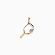 The 14K Yellow Gold Diamond Pickleball Paddle Charm is shaped like a paddle with a small round diamond where the ball would be, shown on a plain white background—an elegant jewelry piece for pickleball lovers.