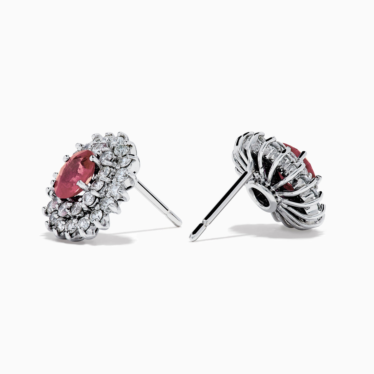 The Ruby Royale 18K White Gold Ruby and Diamond Earrings feature oval red rubies encircled by two halos of sparkling white diamonds, all set in elegant 18K white gold.