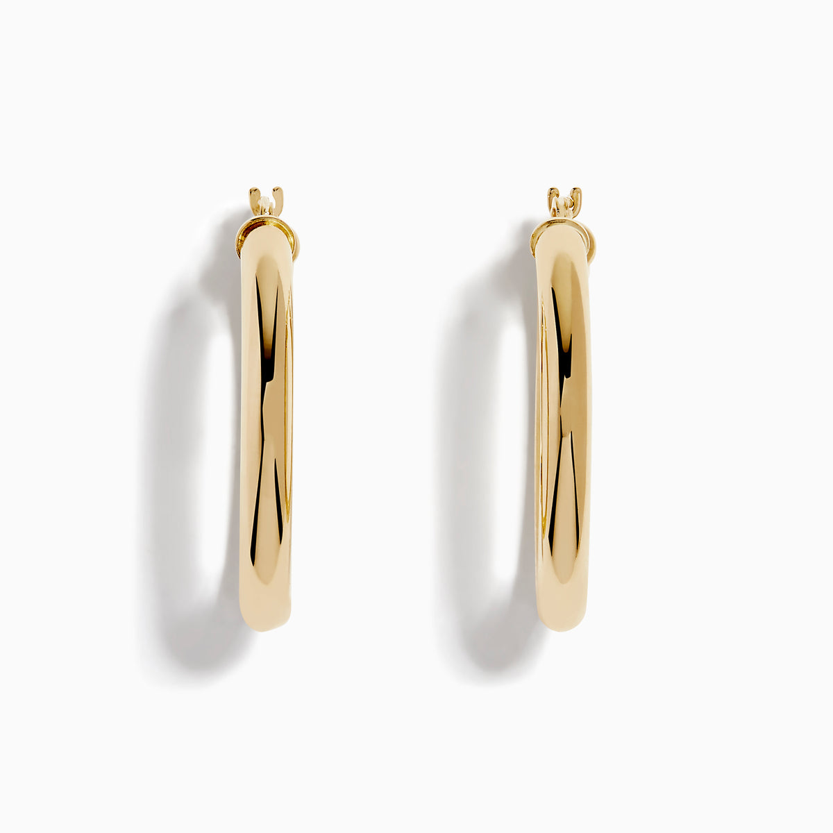A pair of 14K Yellow Gold Hollow Round Hoop Earrings is shown on a white background, with soft shadows cast to the left.
