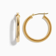 A pair of 14K Yellow Gold Hollow Round Hoop Earrings is shown on a white background, with soft shadows cast to the left.