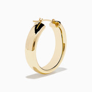 A pair of 14K Yellow Gold Hoops with a smooth, rounded surface shines brightly, displayed vertically against a plain white background.
