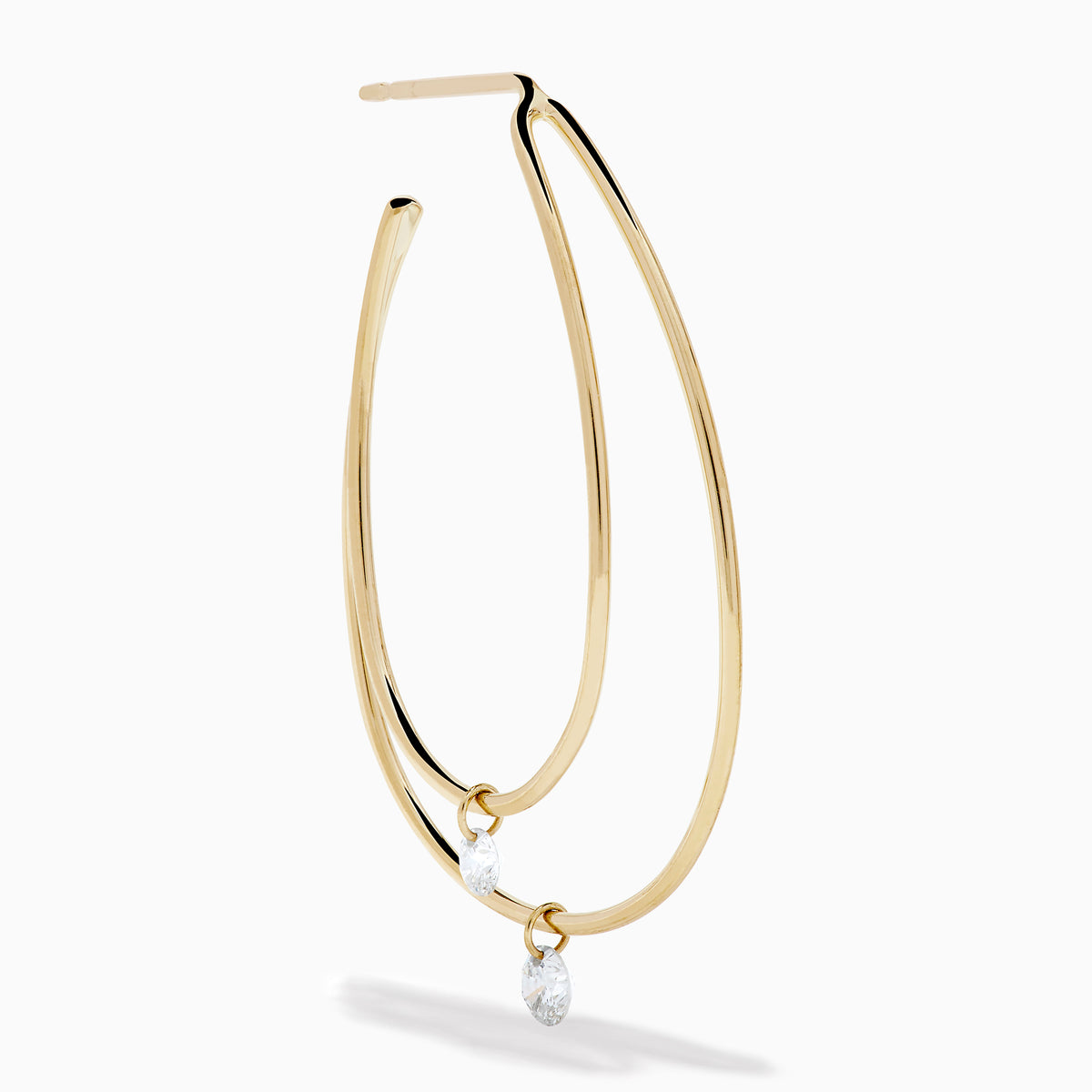 The 14K Yellow Gold Floating Diamond Double Hoop Earrings feature two elongated hoops in yellow gold, each accented with a small floating diamond, and are displayed against a plain white background.