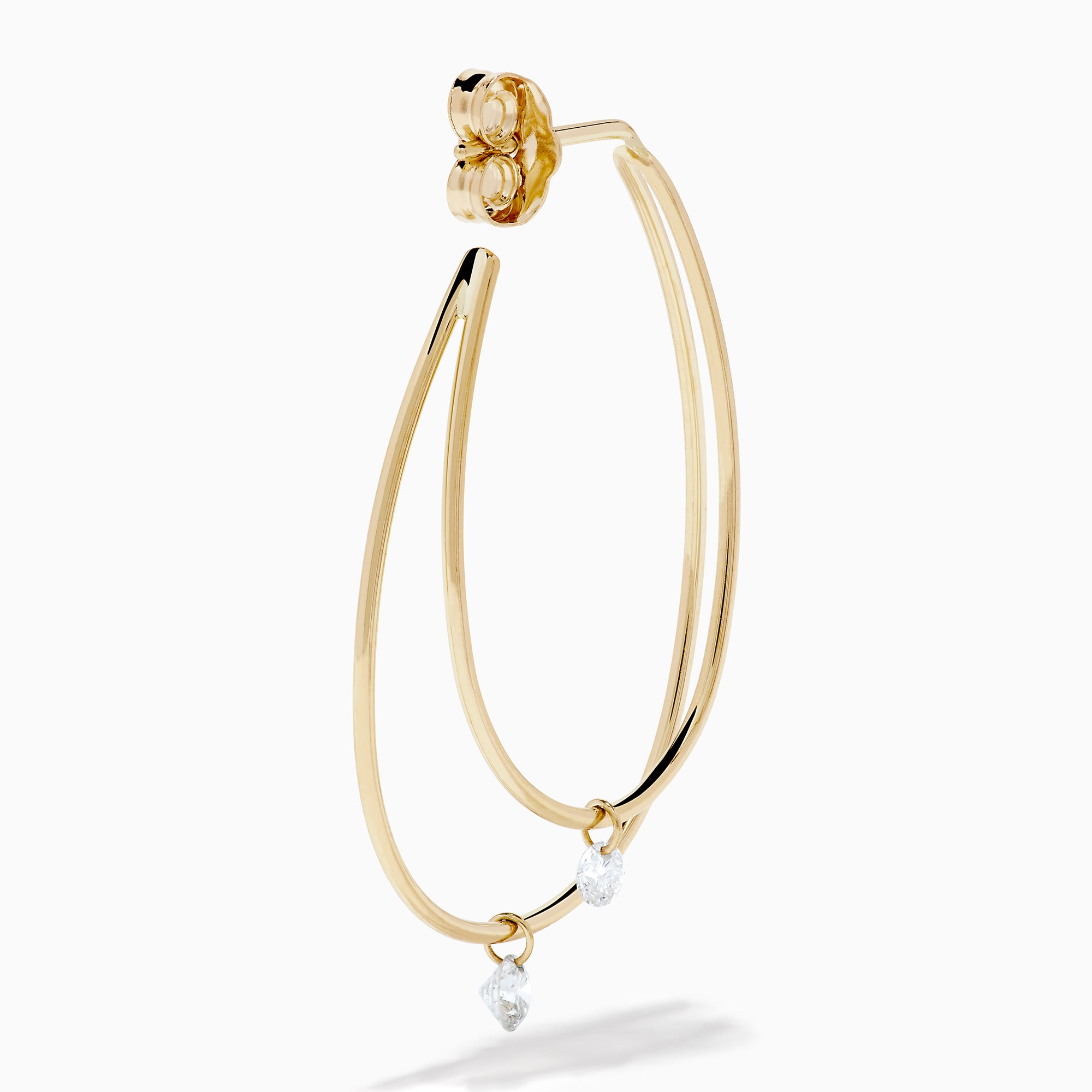 The 14K Yellow Gold Floating Diamond Double Hoop Earrings feature two elongated hoops in yellow gold, each accented with a small floating diamond, and are displayed against a plain white background.