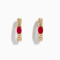 The 14K Yellow Gold Ruby and Diamond Hoops feature a central oval ruby accented by sparkling round diamonds on both sides—a stunning addition to your jewelry collection.