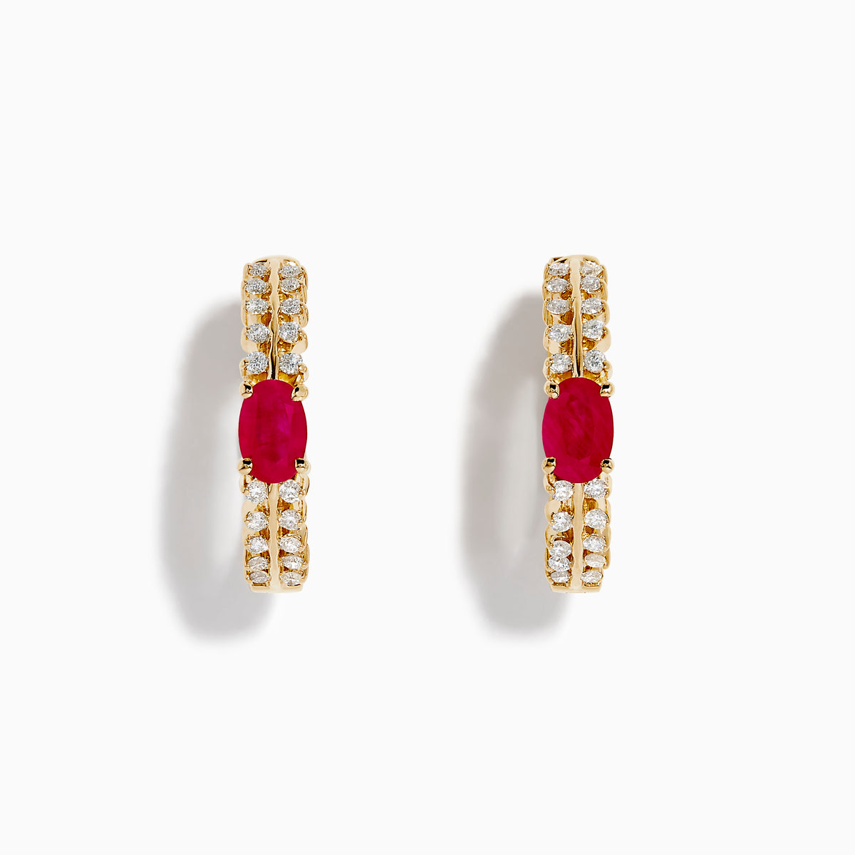 The 14K Yellow Gold Ruby and Diamond Hoops feature a central oval ruby accented by sparkling round diamonds on both sides—a stunning addition to your jewelry collection.