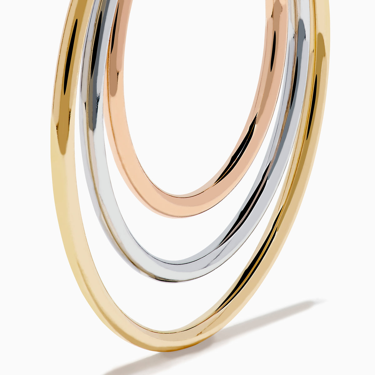 The 14K Three Tone Gold Triple Tube Hoop Earrings are displayed against a white background, with one earring shown front-facing and the other in a side view to highlight the intertwined gold, silver, and rose gold bands.