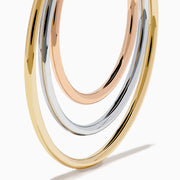 The 14K Three Tone Gold Triple Tube Hoop Earrings are displayed against a white background, with one earring shown front-facing and the other in a side view to highlight the intertwined gold, silver, and rose gold bands.