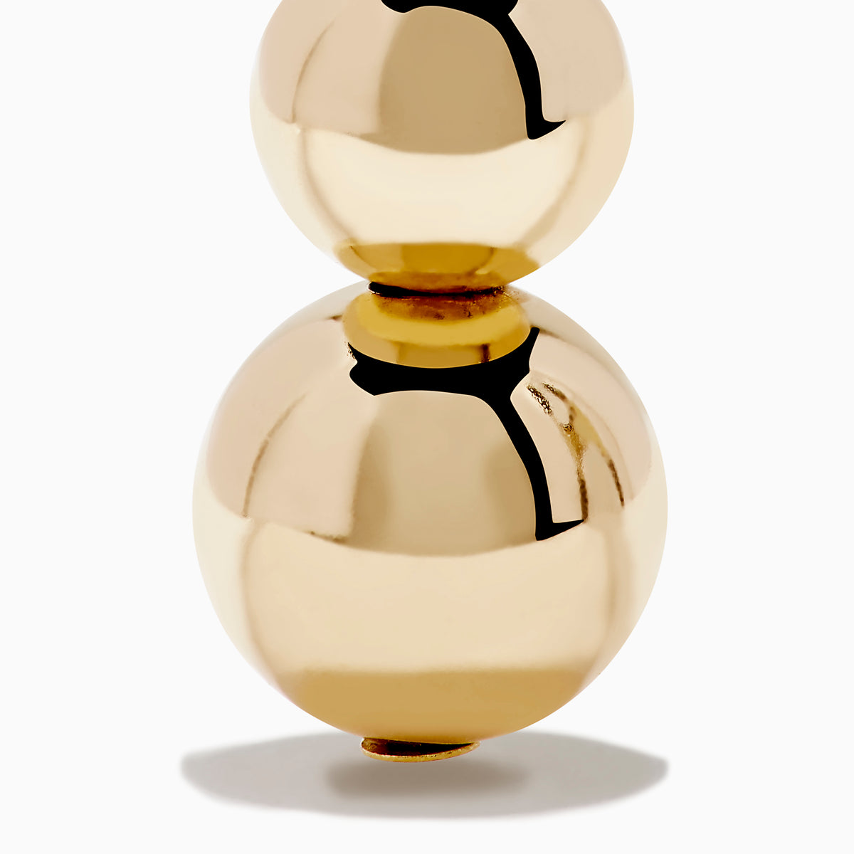 The 14K Yellow Gold Bead Dangle Earrings feature two stacked shiny gold spheres on each earring, suspended from gold hooks with a decorative top detail, shown against a plain white background.