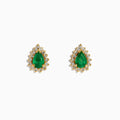 The 14K Yellow Gold Pear Emerald and Diamond Halo Stud Earrings showcase teardrop green emeralds encircled by sparkling diamonds in a floral design.