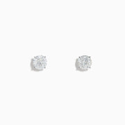 The 14K White Gold 1.18ct Brilliant Round Diamond Solitaire Stud Earrings feature sparkling diamonds in classic prong settings, showcased on a simple white background.