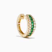 The Brasilica 14K Yellow Gold Emerald and Diamond Huggie Earrings feature a central row of green emeralds bordered by two rows of small white diamonds, shown on a white background.