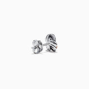 The 14K White Gold Pink Diamond Love Knot Earrings feature an intricate knot design in silver and rose gold tones, accented with sparkling pink diamonds. They are displayed against a plain white background.
