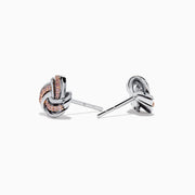 The 14K White Gold Pink Diamond Love Knot Earrings feature an intricate knot design in silver and rose gold tones, accented with sparkling pink diamonds. They are displayed against a plain white background.