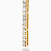 The 14K Yellow Gold Diamond Linear Bar Drop Huggie Earrings feature long, slender vertical bars accented with sparkling diamonds, displayed against a plain white background.