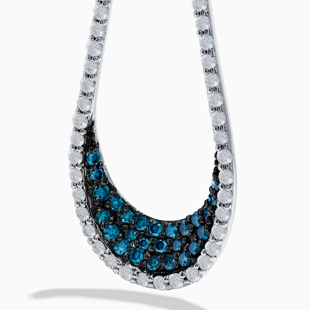 The 14K White Gold Blue and White Diamond Drop Earrings feature teardrop loops accented with sparkling white stones and blue stones near the bottom for a timeless, elegant look.
