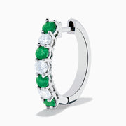 A pair of 14K white gold emerald & diamond hoop earrings, 1.10 TCW, featuring alternating green and clear gemstones set in a silver band, displayed on a white background with soft shadows.