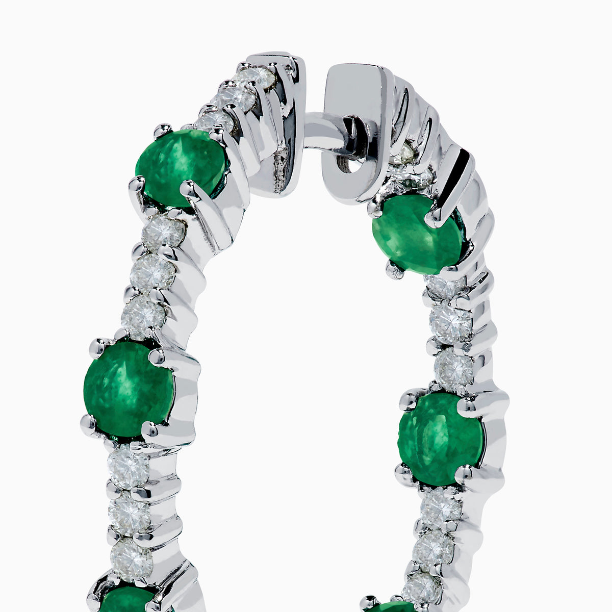 The 14K White Gold Emerald and Diamond Hoops showcase alternating round emeralds and diamonds in silver hoops, displayed against a white background.