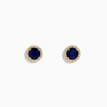 The 14K Yellow Gold Sapphire and Diamond Halo Stud Earrings feature deep blue sapphires at the center, each encircled by sparkling diamonds and displayed on a white background.