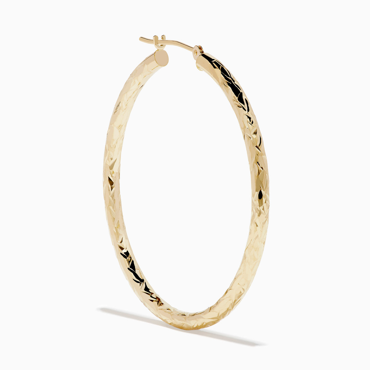 A pair of 14K Yellow Gold Crystal Cut Tube Hoops, large and textured, are displayed vertically on a white background with soft shadows beneath each earring.