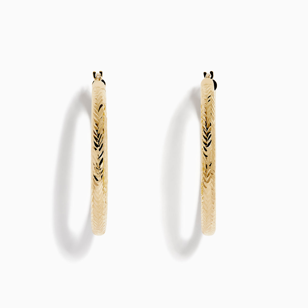 A pair of 14K Yellow Gold Chevron Cut Tube Hoops, displayed against a white background with soft shadows.