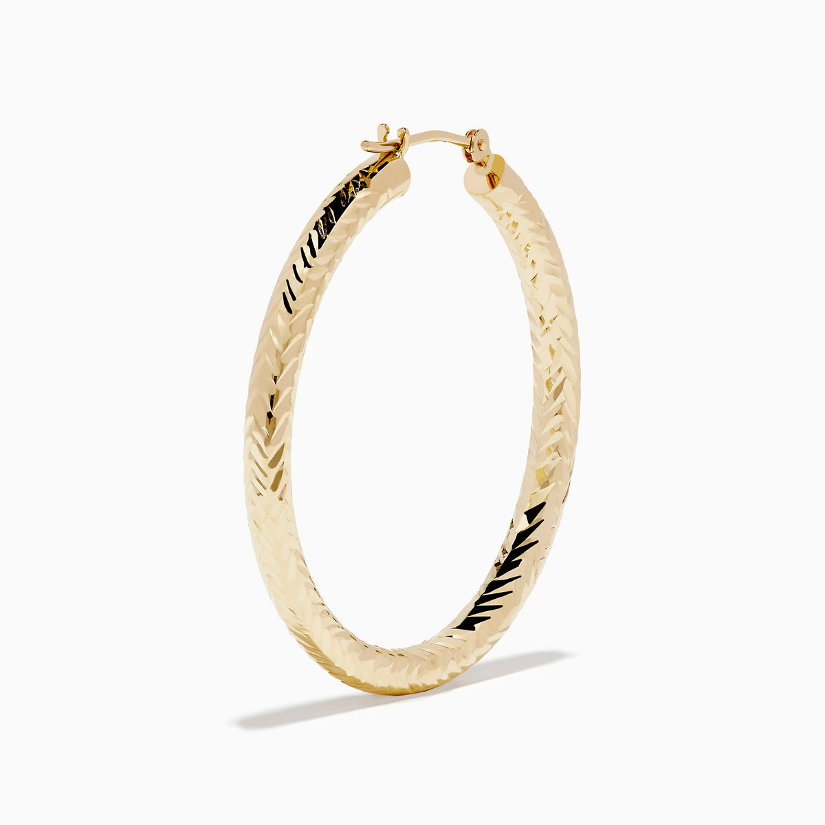 A pair of 14K Yellow Gold Chevron Cut Tube Hoops, displayed against a white background with soft shadows.