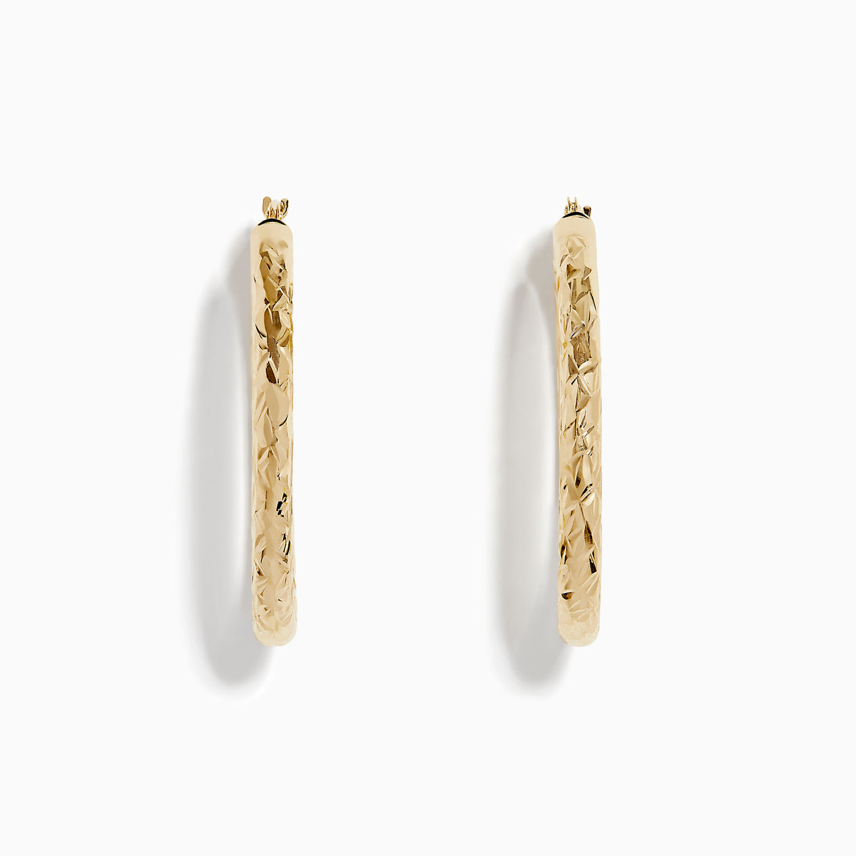 The 14K Yellow Gold Crystal Cut Tube Oval Hoops feature a textured, engraved floral pattern and delicate crystal cut detailing, shown against a plain white background.