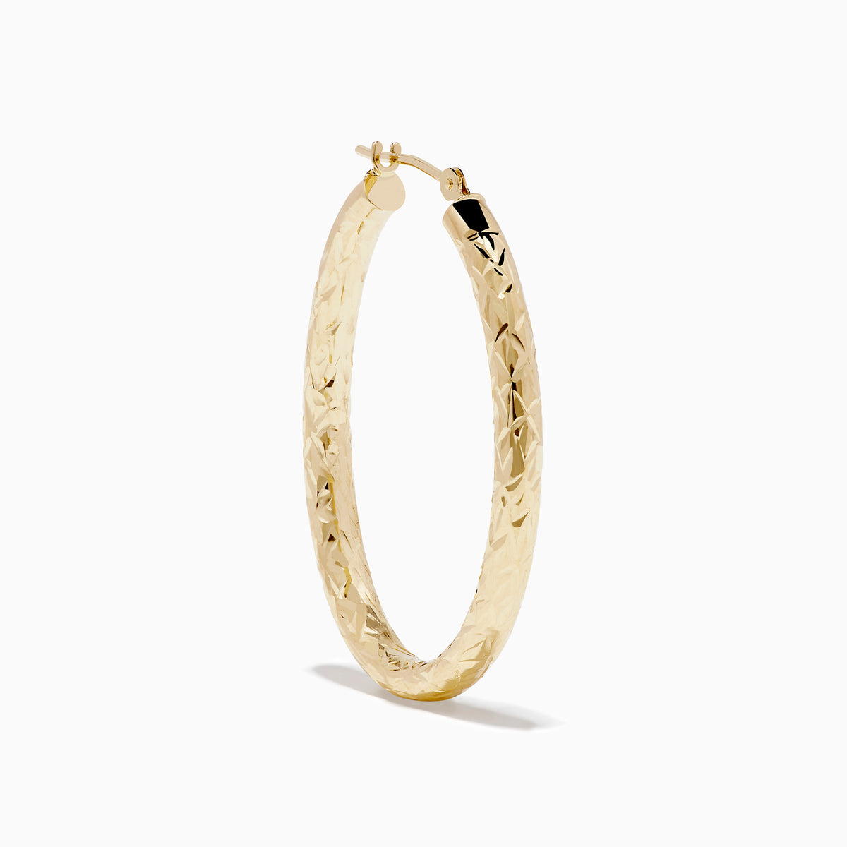 The 14K Yellow Gold Crystal Cut Tube Oval Hoops feature a textured, engraved floral pattern and delicate crystal cut detailing, shown against a plain white background.