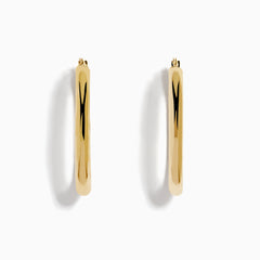 A pair of 14K Yellow Gold Hollow Oval Hoop Earrings displayed vertically on a white background, casting soft shadows to the right.