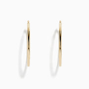 The 14K Yellow Gold Large Tube Hoop Earrings feature a simple, polished design, displayed on a plain white background with subtle shadows.
