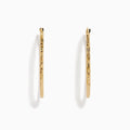 A pair of 14K Yellow Gold Oval Tube Baguette Cut Hoop Earrings, thin and textured, are displayed vertically with clasps at the top against a plain white background.