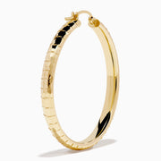 The 14K Yellow Gold Reverse Vibrant Cut Hoop Earrings feature a large, eye-catching design and are showcased against a plain white background with soft shadows.