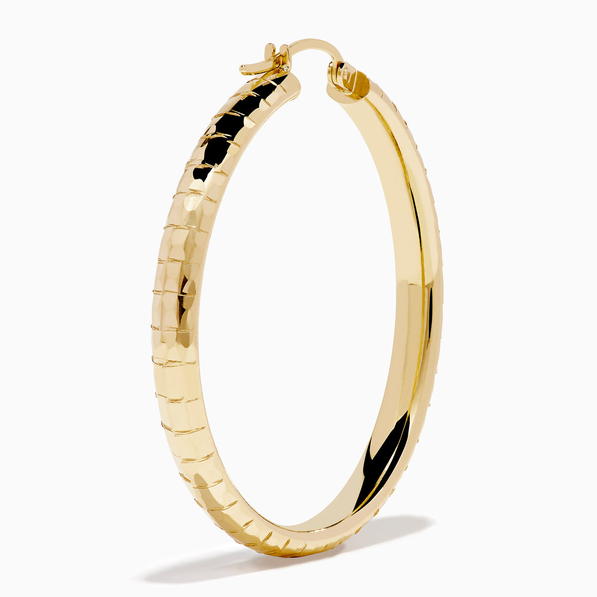 The 14K Yellow Gold Reverse Vibrant Cut Hoop Earrings feature a large, eye-catching design and are showcased against a plain white background with soft shadows.