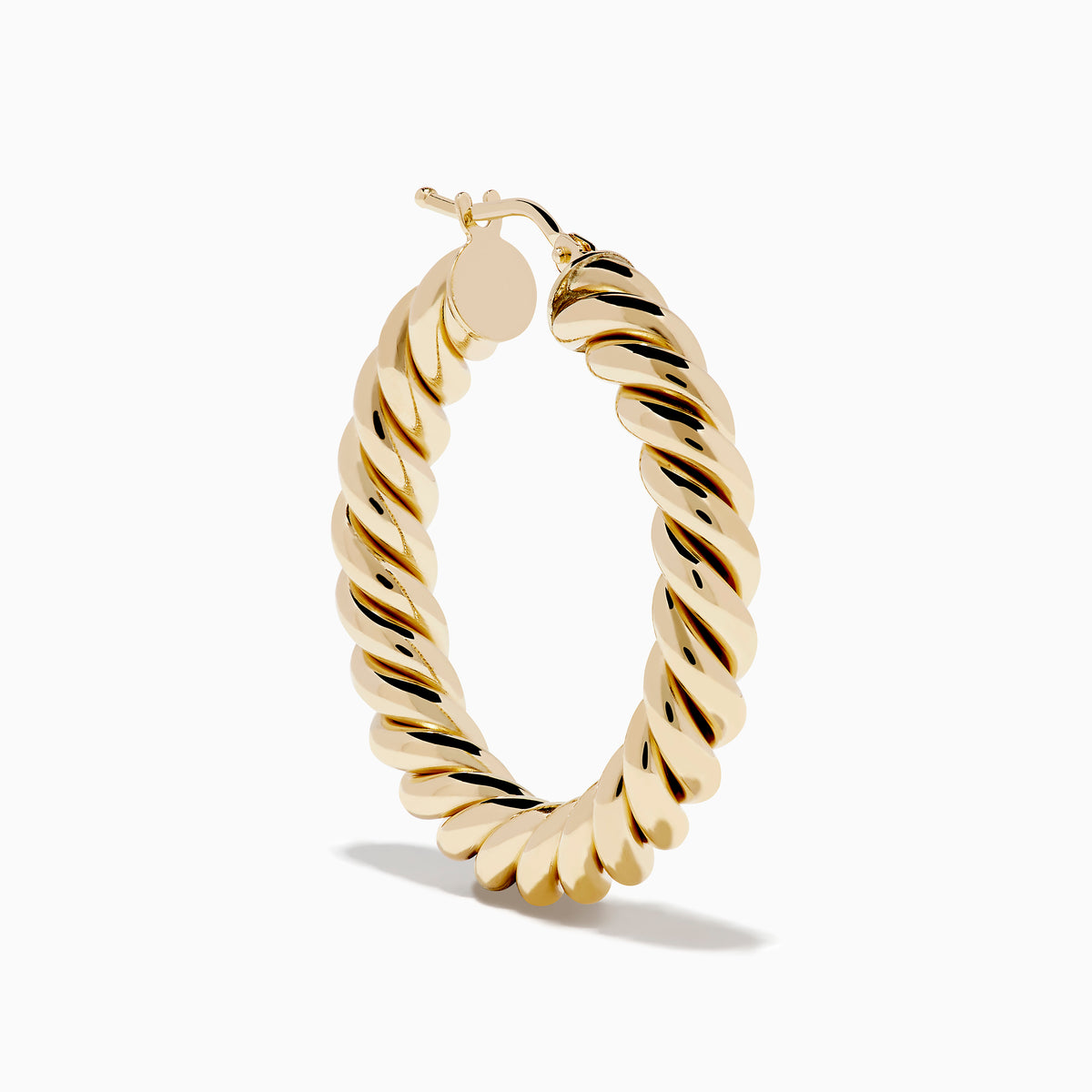The 14K Yellow Gold Twisted Tube Hoops are shown on a white background, with gentle shadows highlighting their elegant design.