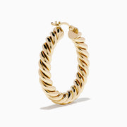 The 14K Yellow Gold Twisted Tube Hoops are shown on a white background, with gentle shadows highlighting their elegant design.