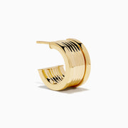 The 14K Yellow Gold Chunky Huggie Earrings feature a ridged, cylindrical design and are shown against a white background.