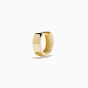 The 14K Yellow Gold Huggies are simple, small earrings with a smooth, shiny finish, shown on a plain white background.