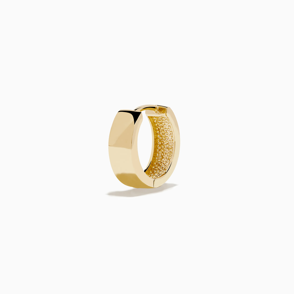 The 14K Yellow Gold Huggies are simple, small earrings with a smooth, shiny finish, shown on a plain white background.