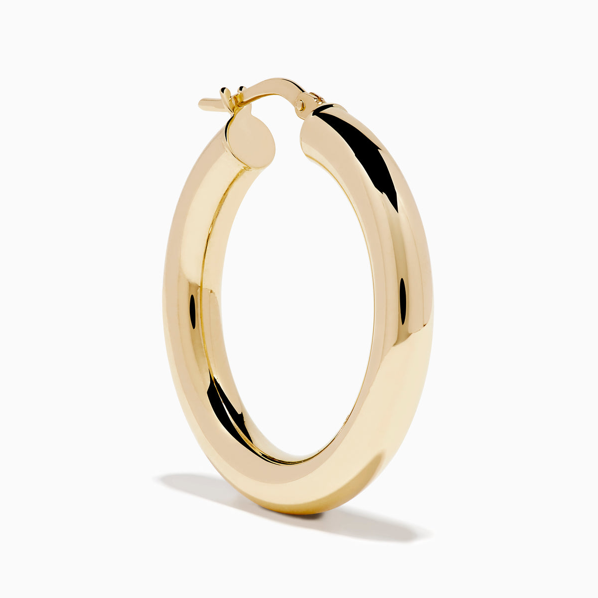 The 14K Yellow Gold Tube Hoop Earrings are shown vertically on a plain white background, with soft shadows cast to the left.