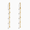 The 14K Yellow Gold Linear Drop Earrings showcase a minimalist design with slim chains and small, spaced gold beads. Crafted in 14K yellow gold, these earrings hang vertically from hooks for a timeless, elegant style.