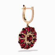 The 14K Rose Gold Rhodolite and Diamond Floral Dangle Earrings showcase large floral designs with deep red rhodolite gemstone petals, accented by clear stones and a diamond circle at the center.