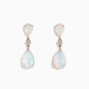 The 14K Rose Gold Opal and Diamond Drop Earrings feature pear-shaped opals and round diamond accents set in rose gold, offering a delicate, shimmering look against a white background.